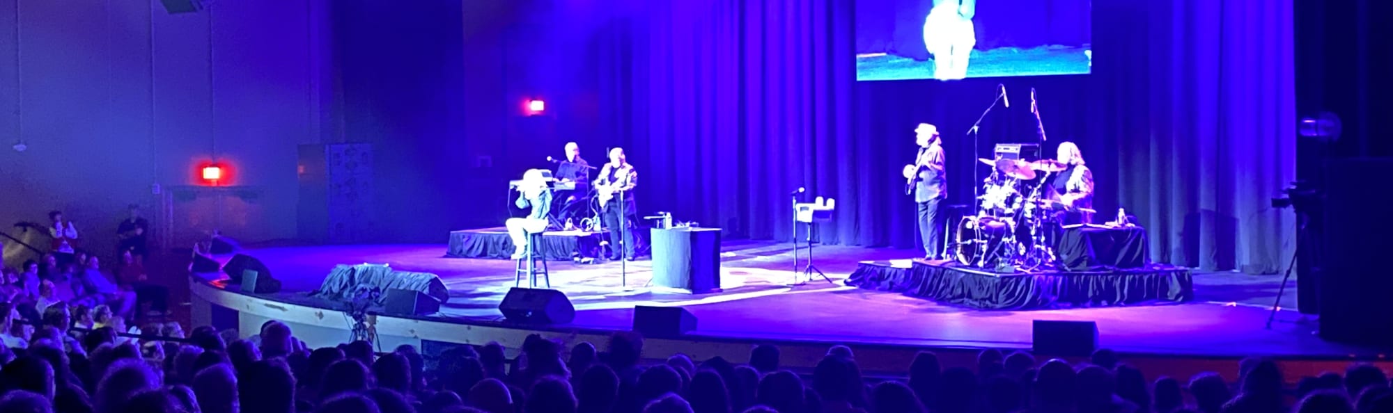 signer on stage in chair washed out by the lights Madison